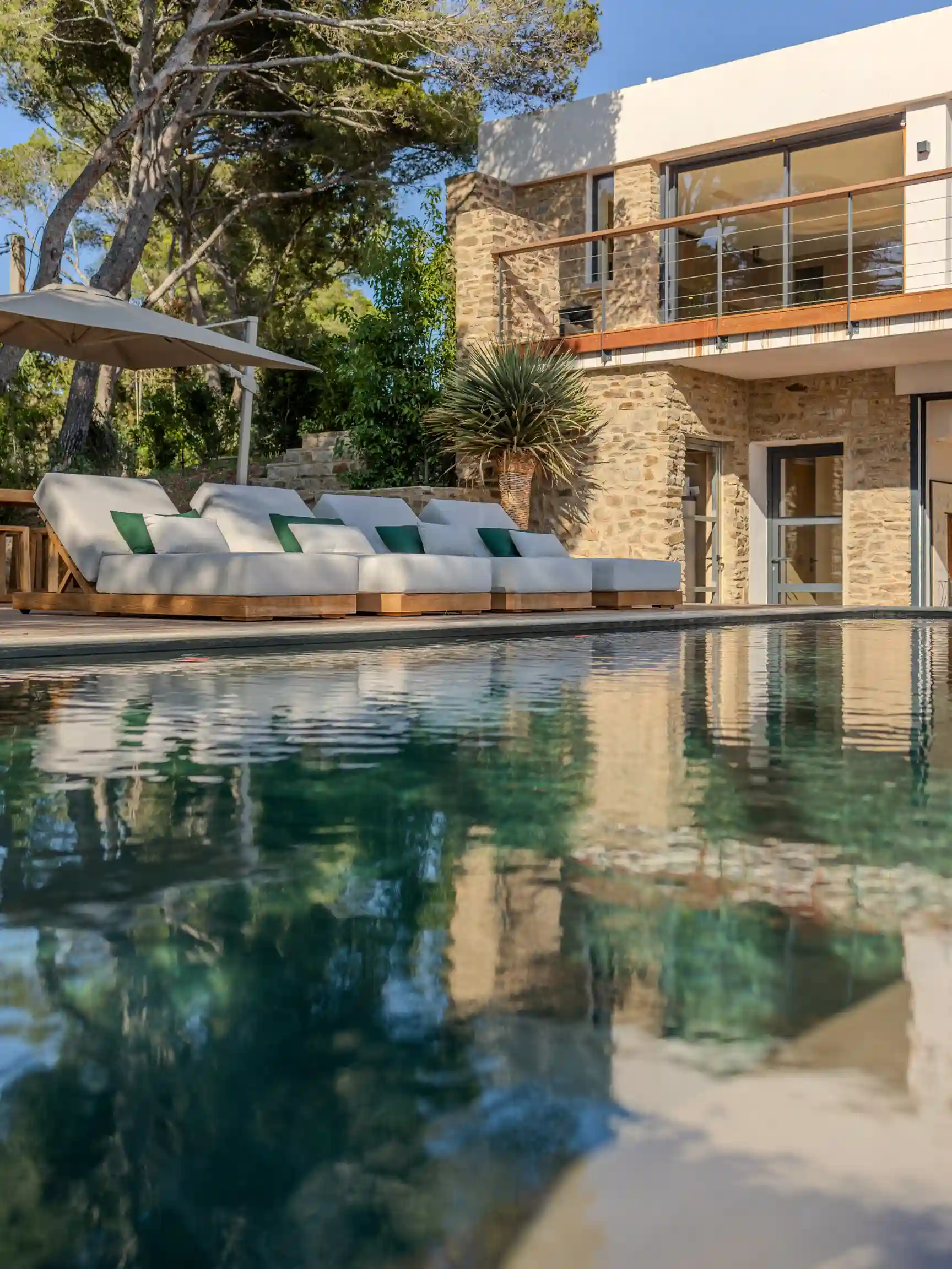 Réalisation d'un architecte paysagiste à Hyères : aménagement de jardin de luxe avec piscine miroir et terrasse en bois pour une villa dans le Var.