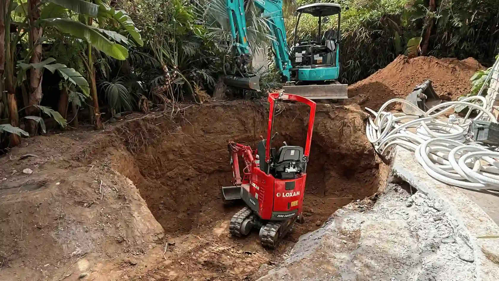 Chantier de terrassement pour une piscine lagon dans le Var : utilisation de mini-pelles pour le creusement de la forme libre et pose des réseaux hydrauliques au cœur d'un jardin tropical.