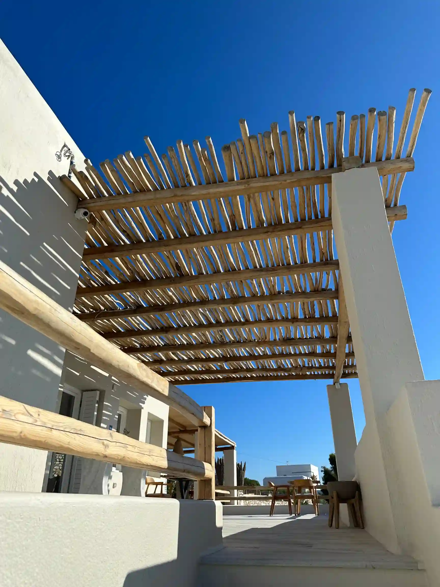 Conception d'une pergola sur mesure en bois flotté sur une terrasse blanche. Solution d'ombrage naturel et design méditerranéen pour une villa dans le Var.
