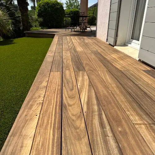Pose technique d'une terrasse en bois avec alignement rigoureux des lames et finitions de précision. Aménagement extérieur haut de gamme avec vue sur le jardin à Hyères.