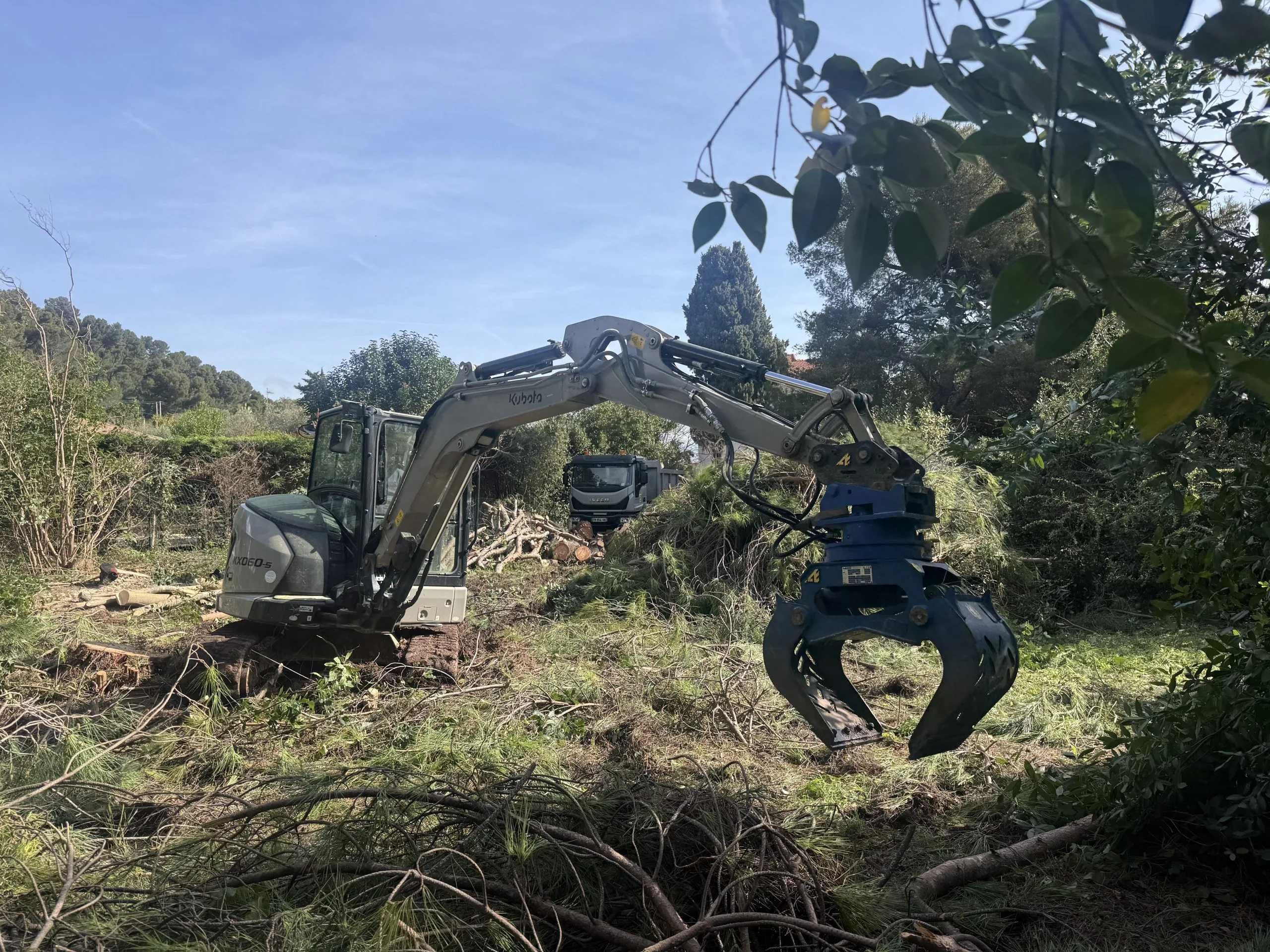 Élagage de terrain avec mini-pelle et grappin à Hyères dans le Var